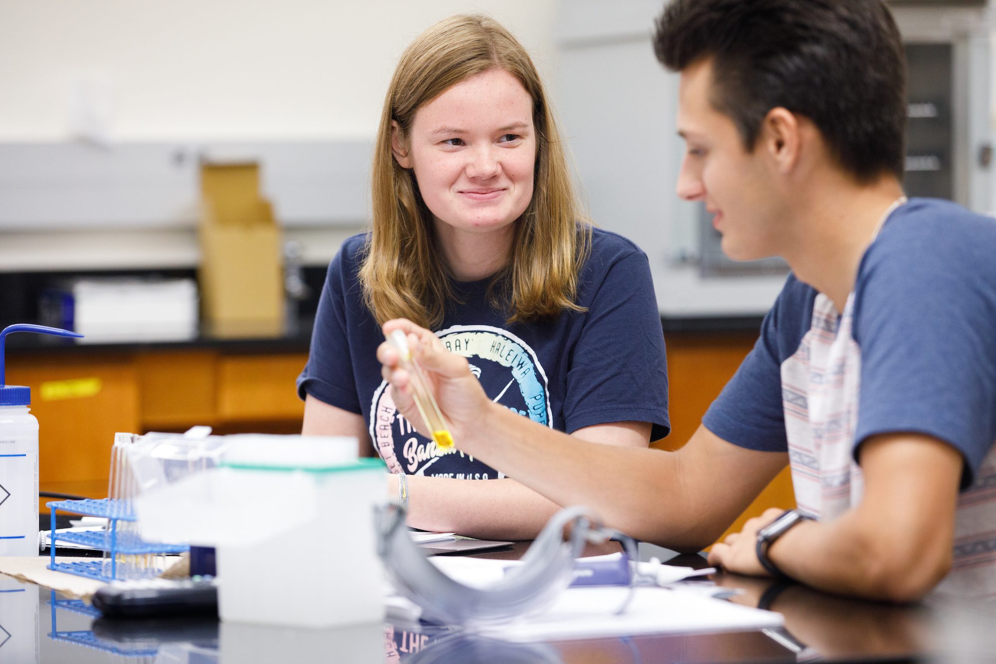 A student holding a test tube in the laboratory.