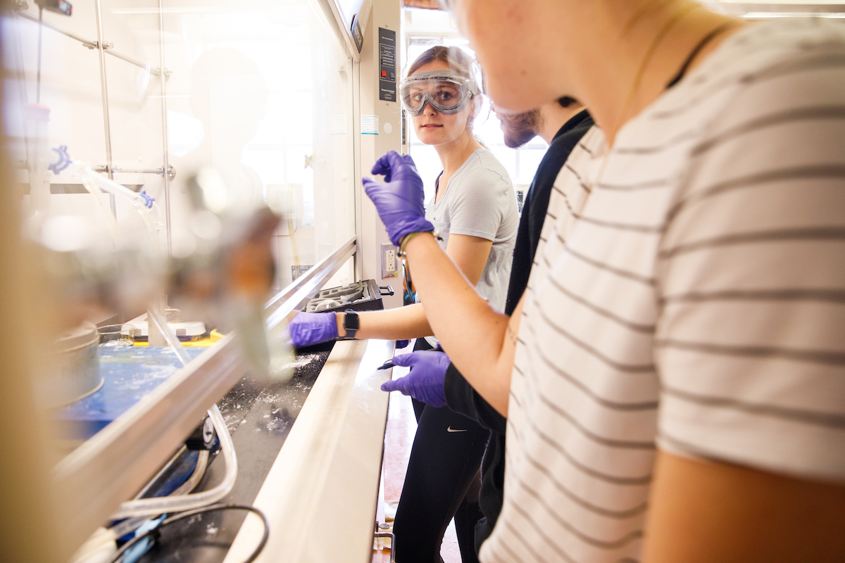 Three students working in a lab on campus