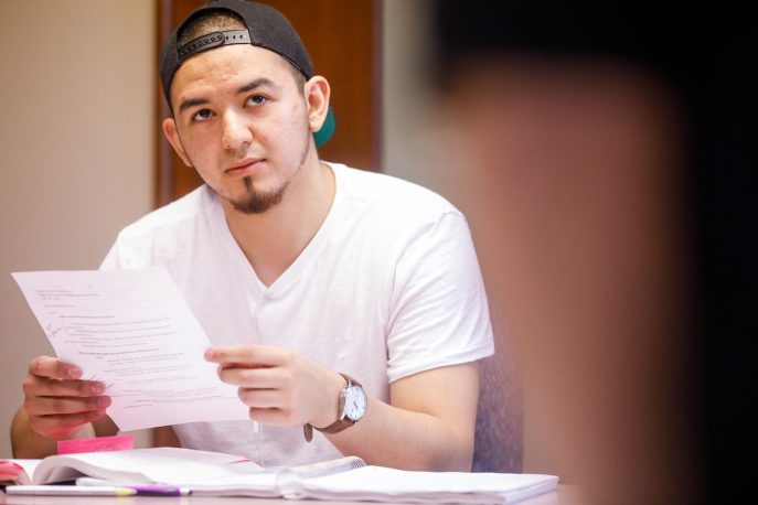 Student holding a piece of paper in a classroom