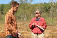 Two people standing in a field.