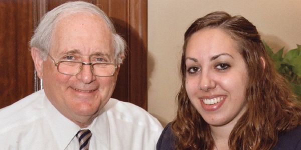 A headshot of a man and a student smiling at the camera.
