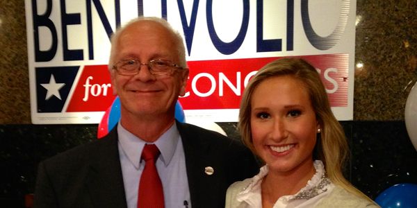 A man in a tie standing next to a student.