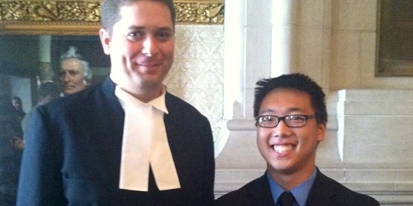 A student standing next to a man in front of a building.