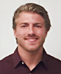 A headshot of a student smiling at the camera wearing a dark red shirt.