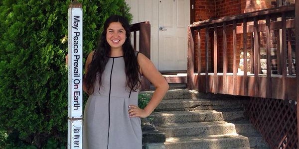 A smiling student in front of a builidng.