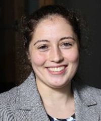A headshot of a student smiling at the camera wearing a gray shirt.