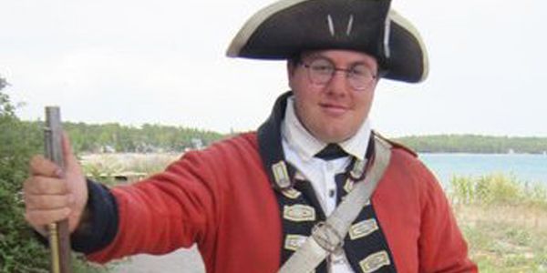 A student outside wearing historical clothing.