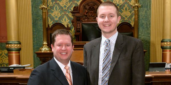 A student standing next to a man.