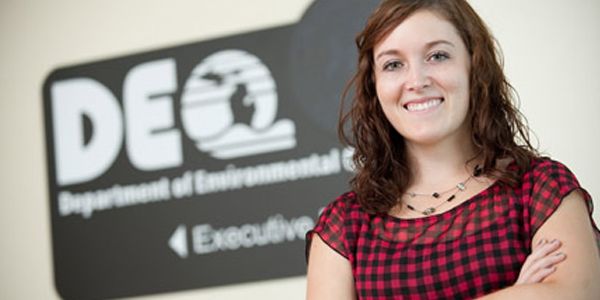 A smiling student wearing a red and black checked shirt.
