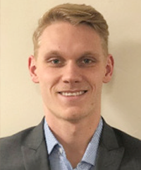 A headshot of a smiling student wearing a suit.
