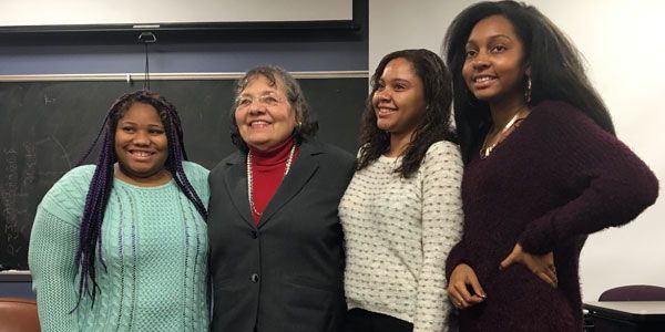 Four people standing in a row.