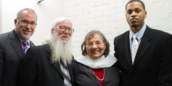 Four people standing in a row.
