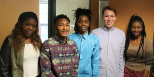 A group of five students standing in a row.