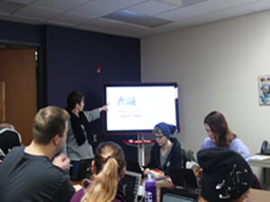 A professor standing at the front of the classroom teaching.