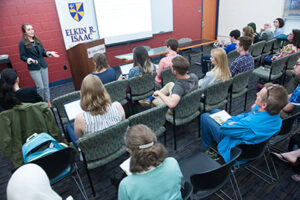 A classroom full of people watching a speaker.