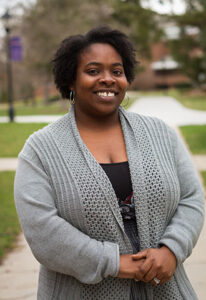 A woman wearing a gray cardigan.