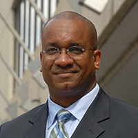 A headshot of a man wearing a suit.
