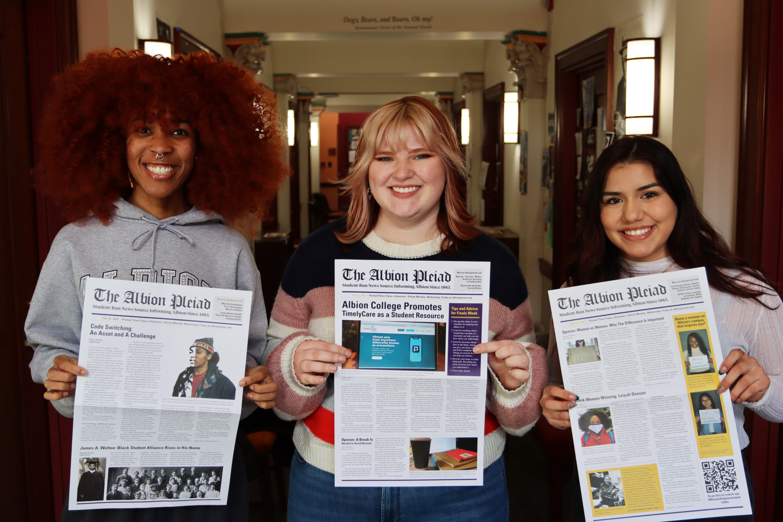 A photo of Sam Semerau and Irene Corona-Avila holding newspapers up.