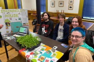 Students sitting at a table next to a poster.