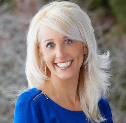 Melissa is smiling wearing a blue sweater