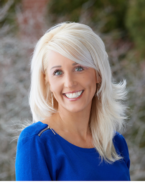 Melissa is smiling wearing a blue sweater