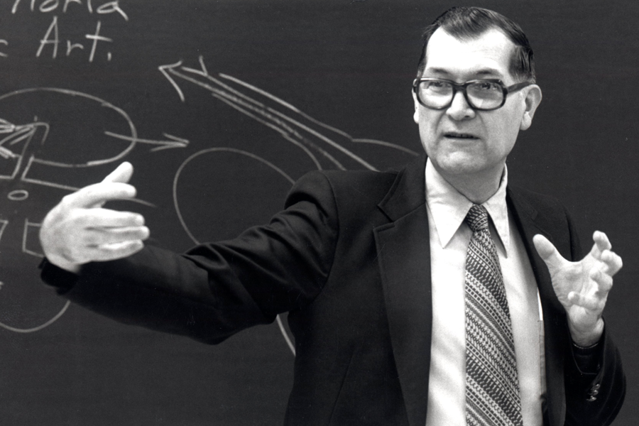 Dean Dillery lecturing in front of blackboard.