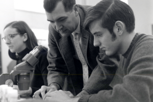 Dean Dillery points at a text book that a student is reading. 