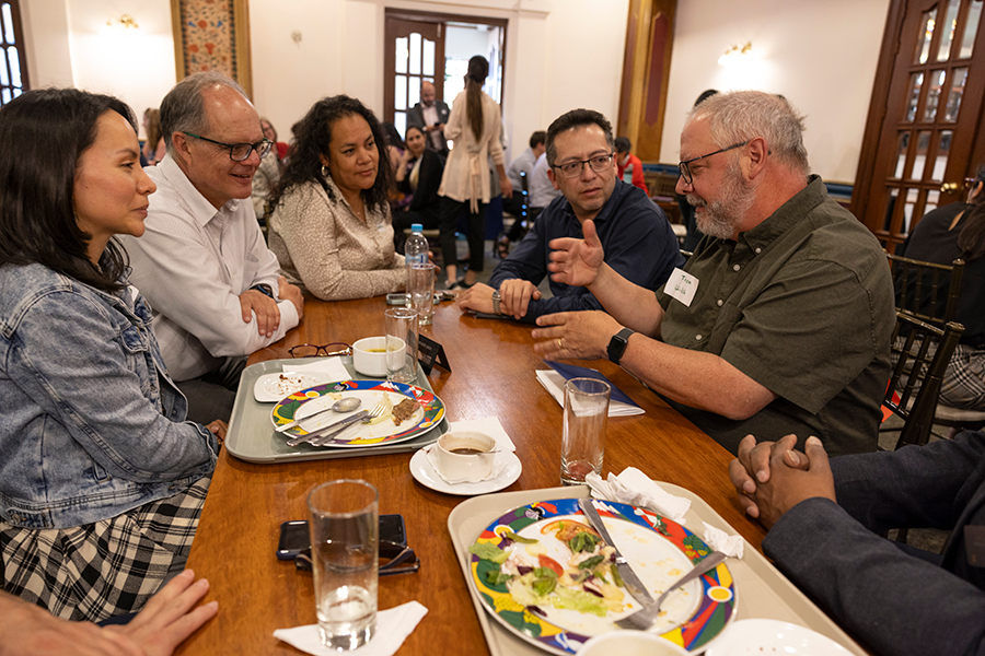 Professor Thom Wilch speaks to the USFQ faculty at a table.
