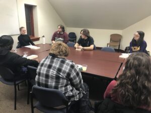 People sitting around a table with Braiding Sweetgrass books